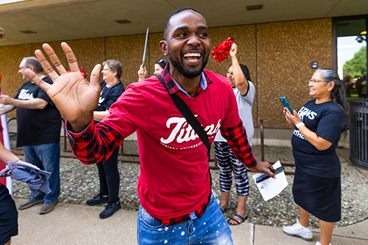 Happy student waving at convocation